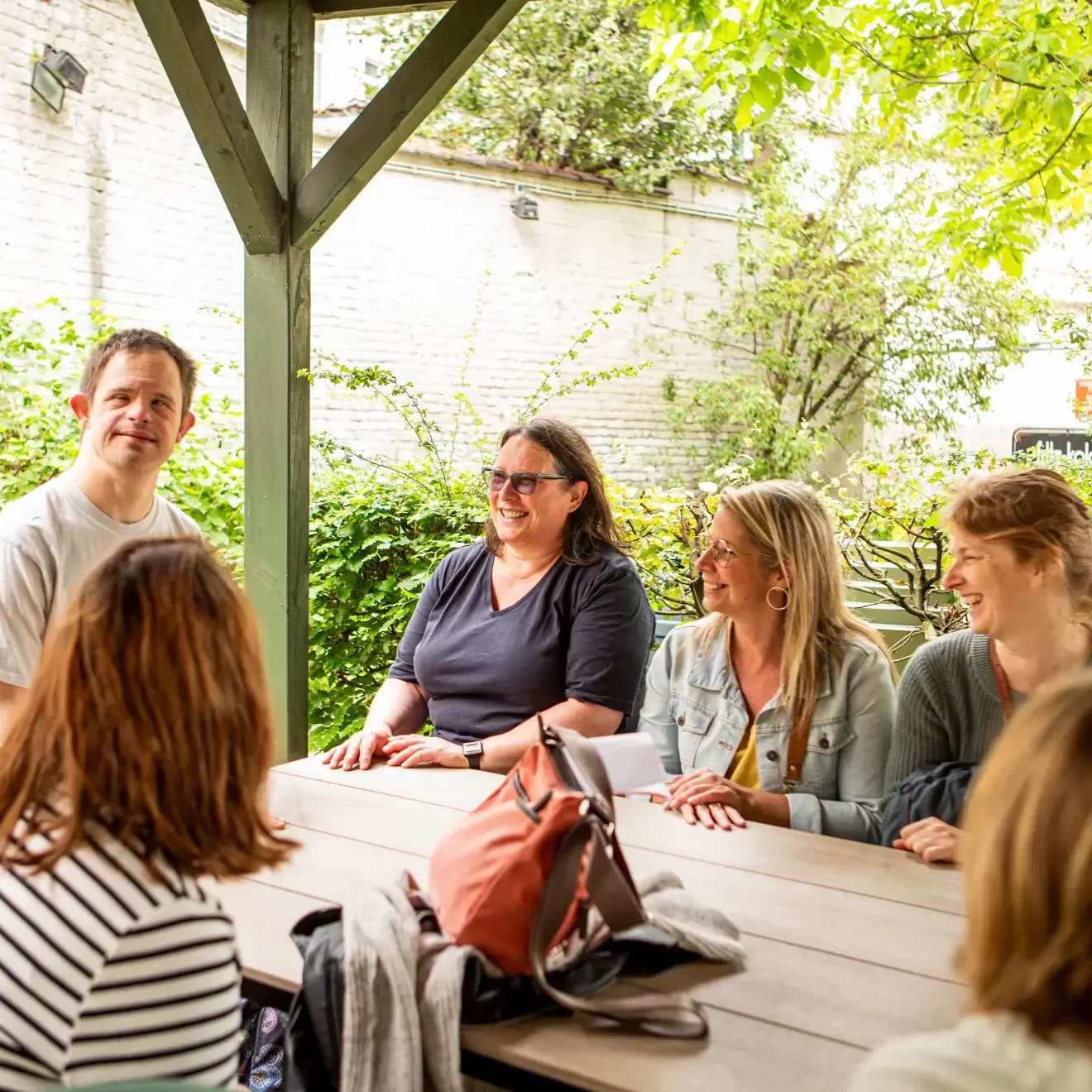 Mensen die lachen en rond een tafel zitten