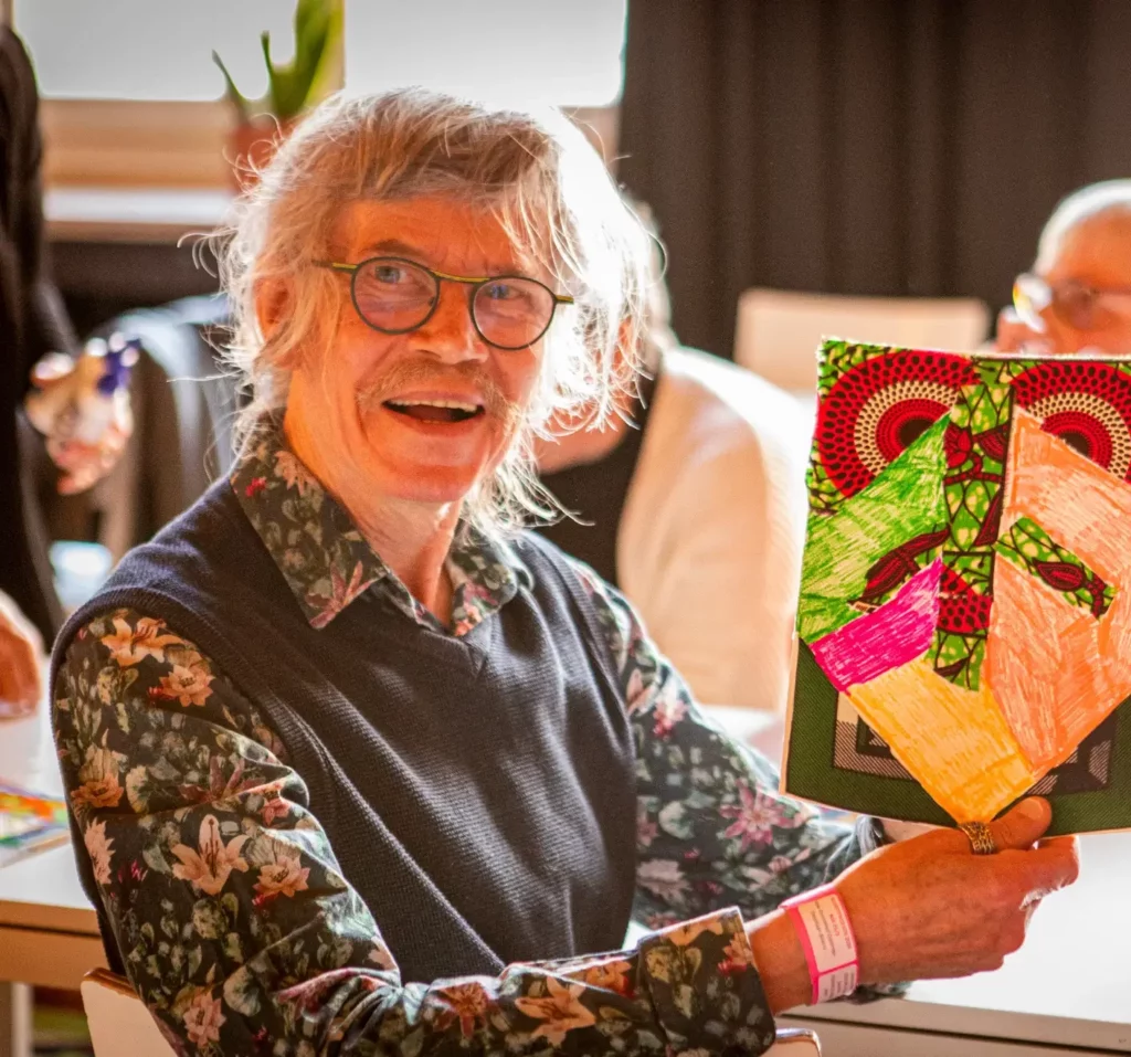 Man die lacht houdt een boekje vast